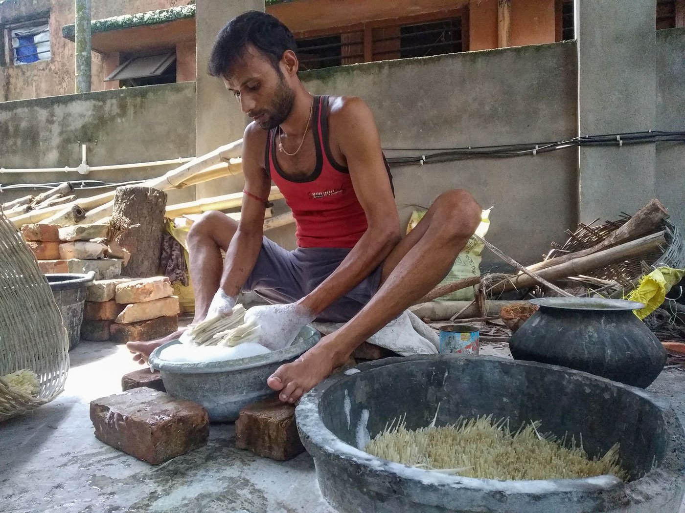 Ranjit Mandal is washing white duck feathers, the first step in shuttlecock making
