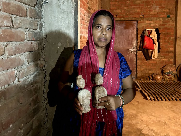 Maya Prajapati showing the dolls made by her in her house