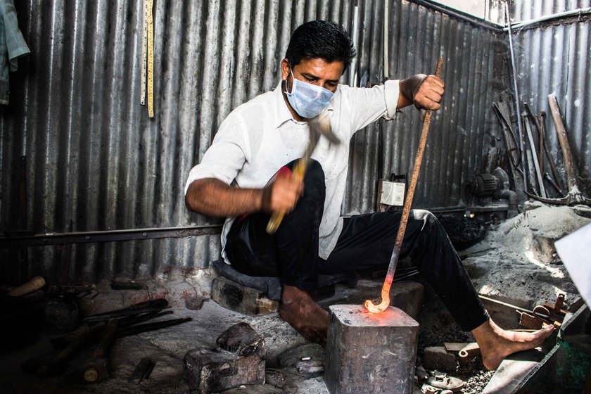 Dilawar (left) meticulously files off swarfs once the nut cutter’s basic structure is ready; Salim hammers an iron rod to make the lower handle of an adkitta

