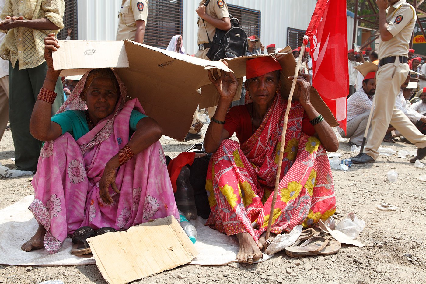 Two women sitting at Azad maidanIn Mumbai, covering their heads with cardboard boxes in the blistering heat.