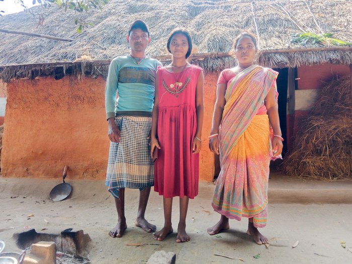 Sombari standing with her parents, Diwaram and Malati Baske in front of their home in Jharia village in Purbi Singhbhum district of Jharkhand