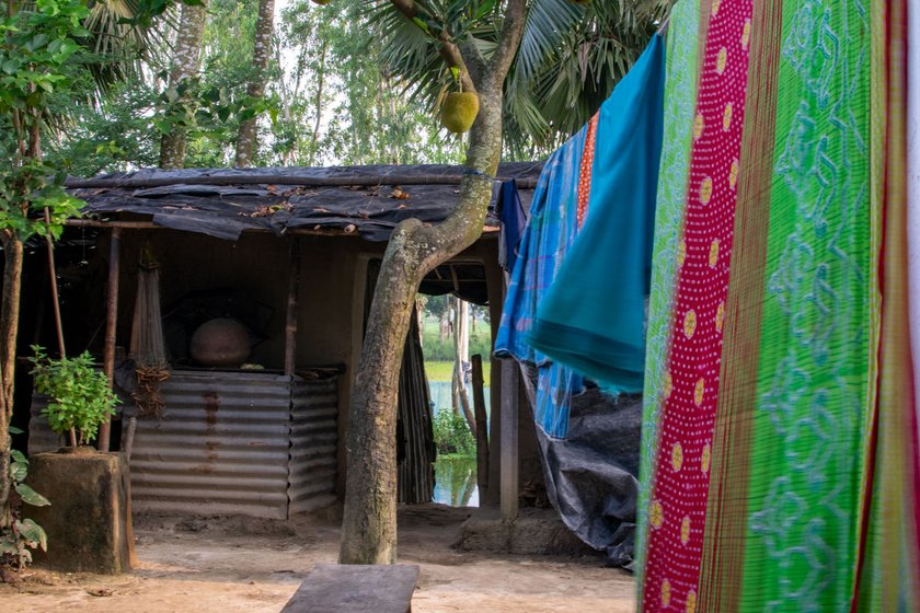 Built under the Pradhan Mantri Awas Yojana, Laxmi's house has a small pond in the backyard (left), and a kitchen with tarpaulin and tin walls and a mud floor (right) 