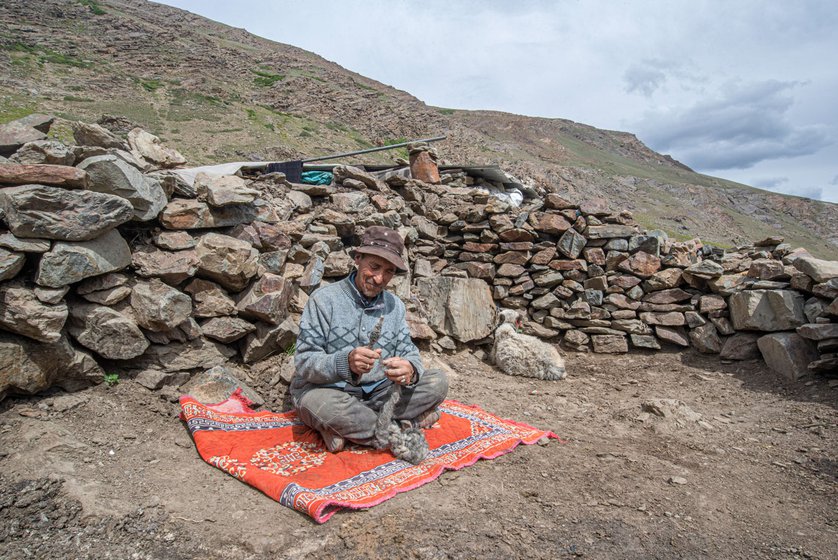 Sonam Motup knitting with yak wool in his doksa (settlement) during some free time in the afternoon.
