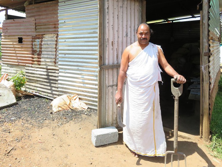 Kollel Rangan is also a Kota priest and must wear the traditional Kota dress even while working at his smithy. He is holding a large size sickle and rake once used to clear the hills for agriculture. 