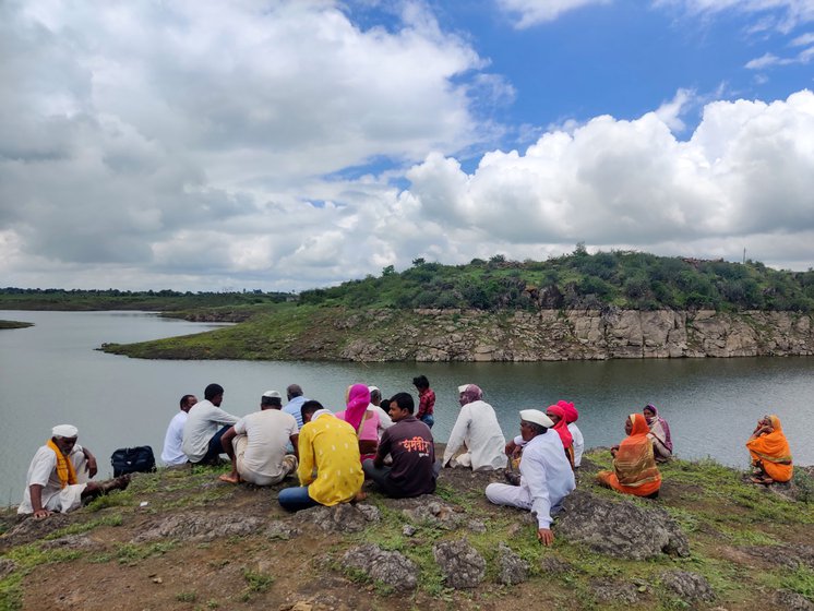 Left: Residents of Shinde Wasti waiting to reach the other side of Sautada village. Right: They carefully balance themselves on rocks to climb into the unsteady rafts