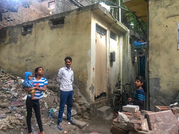 Rukhasana’s husband, Mohammed Wakil, and their children outside their rented room.
