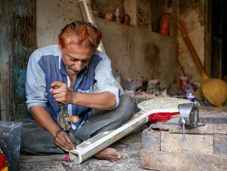 Left:  Irfan Sitarmaker carves patterns and roses on the sitar's handle using a hand drill.