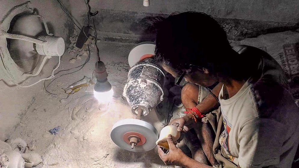 Sushanta Dhar at his mahajan’s workshop in the middle of shaping the conch shell