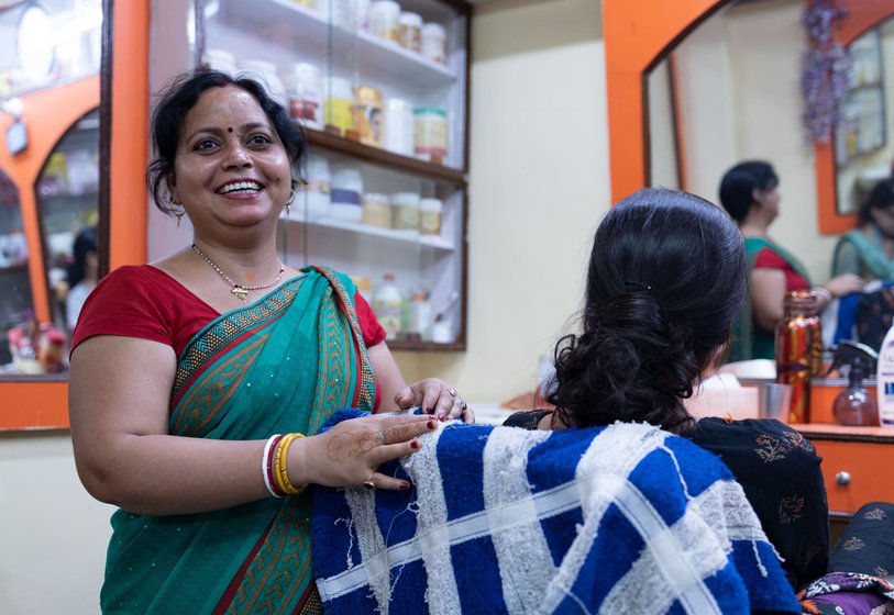 Pramila in her parlour with a customer