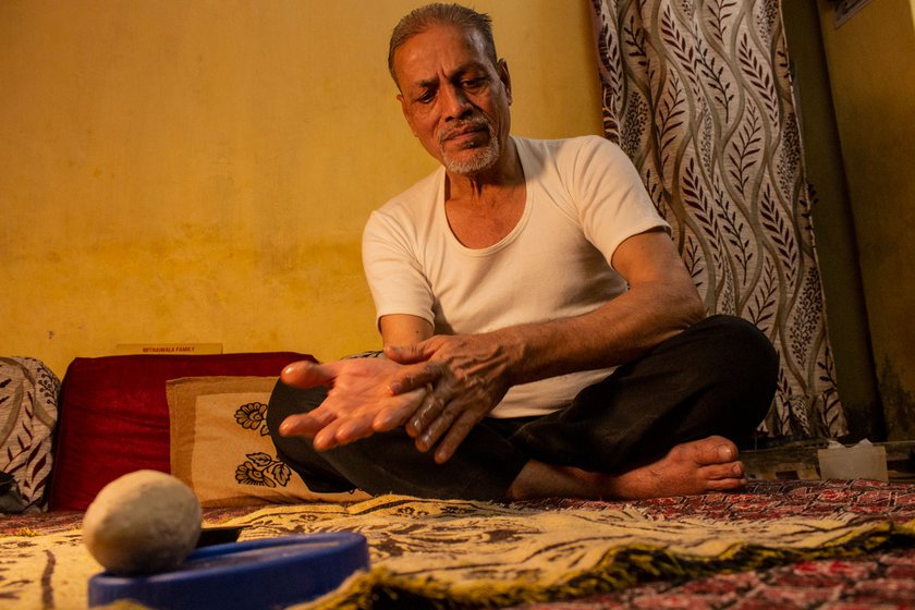 Right: Mustansir Ujjaini applying warm kokum oil on his sore hands