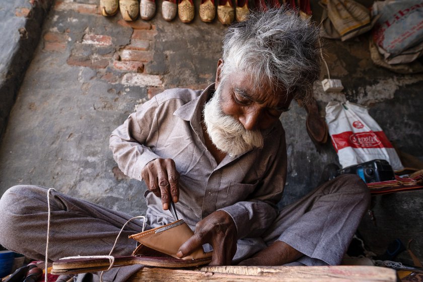 Hansraj has been practicing this craft for nearly half a century. He rolls the extra thread between his teeth before piercing the tough leather with the needle