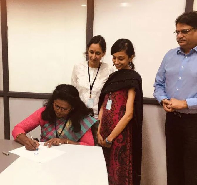 Thivya signing the Dindigul Agreement with Eastman Exports Global Clothing on behalf of TTCU