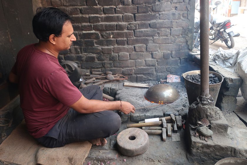 Sunil Kumar heats the inside of the kadhai to remove the green stains caused by oxidation