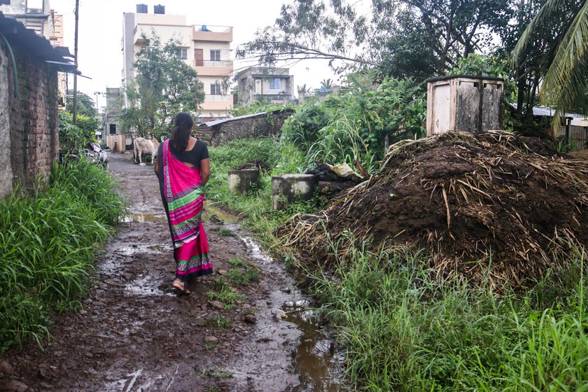 Shubhangi walking to a remote part of Arjunwad village to conduct health care surveys. ASHAs like her deal with rains, heat waves and floods without any aids