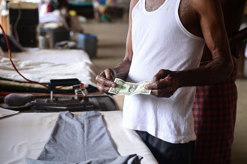Right: Jayaprakash showing a tourist's gift of a dollar bill