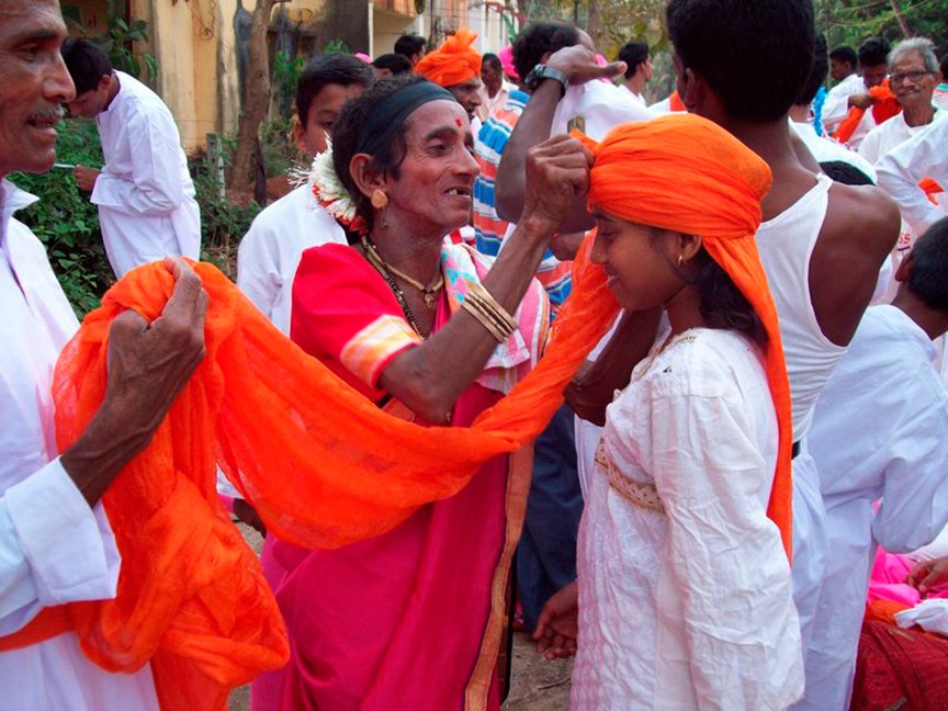 A woman ties a yellow turban