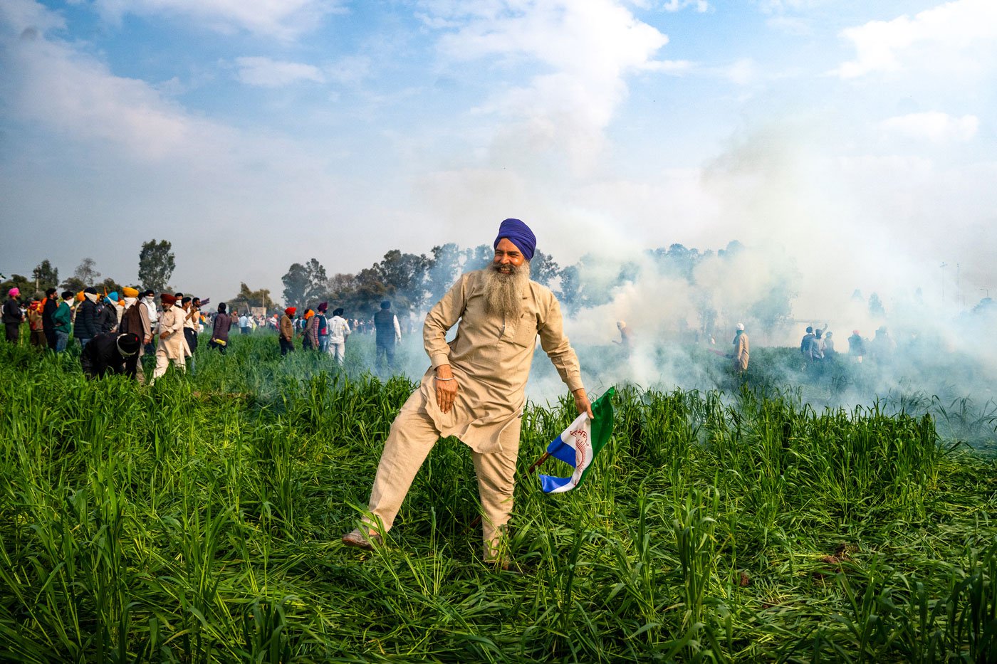A farmer celebrates after successfully diffusing a tear gas shell with his stick at the Punjab-Haryana Shambhu border