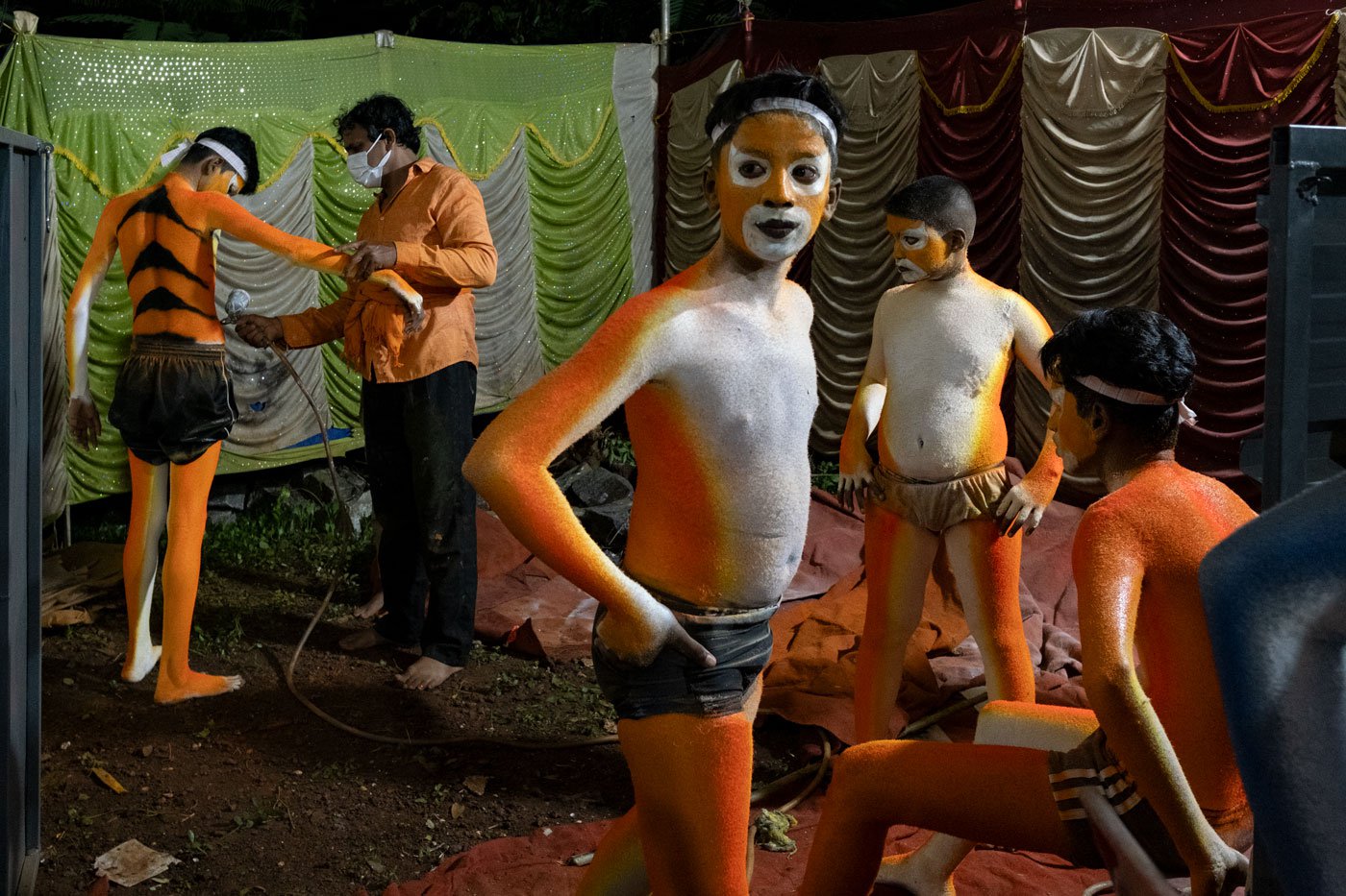 (Left to right) Nikhil, Krishna, Bhuvan Amin and Sagar Poojari wait for their turns as Jayakar Poojari paints tiger stripes on their bodies