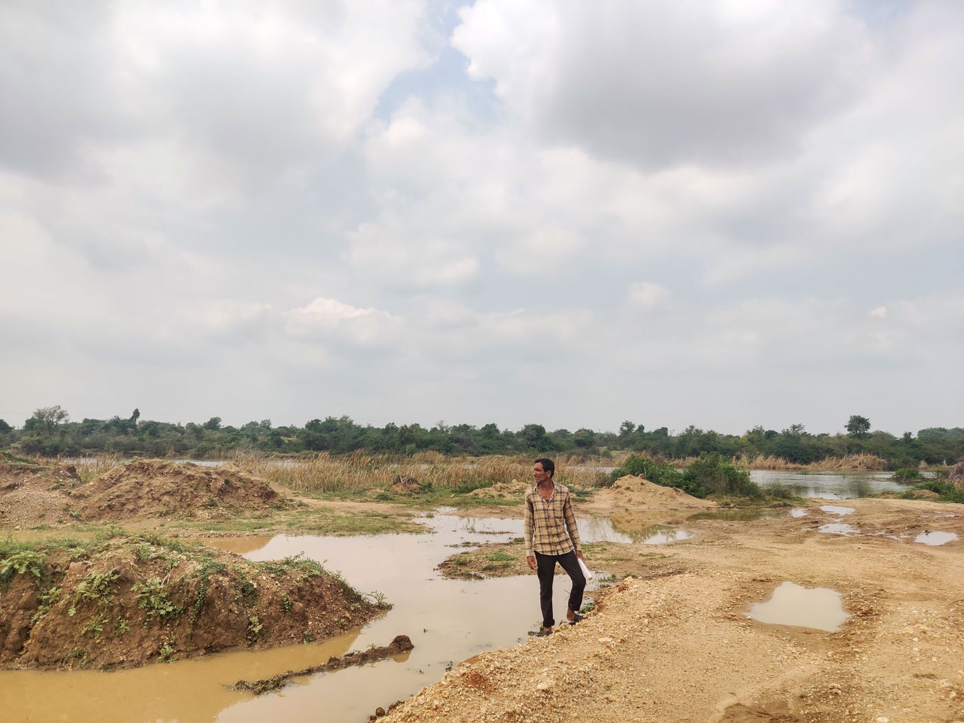Chhaganbhai Pitambar standing on the land allotted to him in the middle of Chandrabhaga river in Surendranagar district