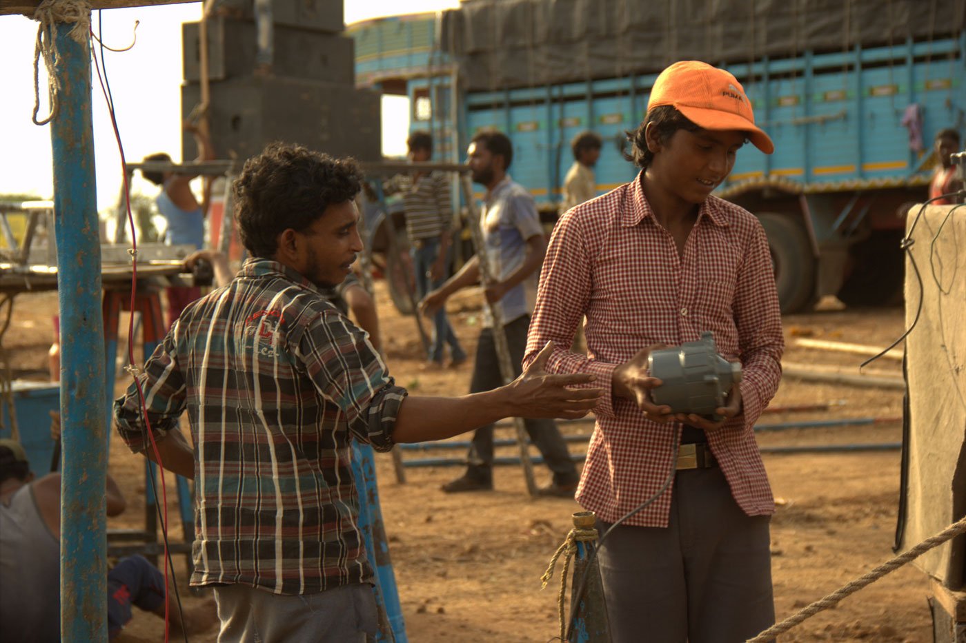 Santram Rawat teaches Aravind Kumar about sound equipment on 4 May 2018 in Karavadi village, Satara district, in western Maharashtra. Both are from Aumau village, Lucknow district, UP