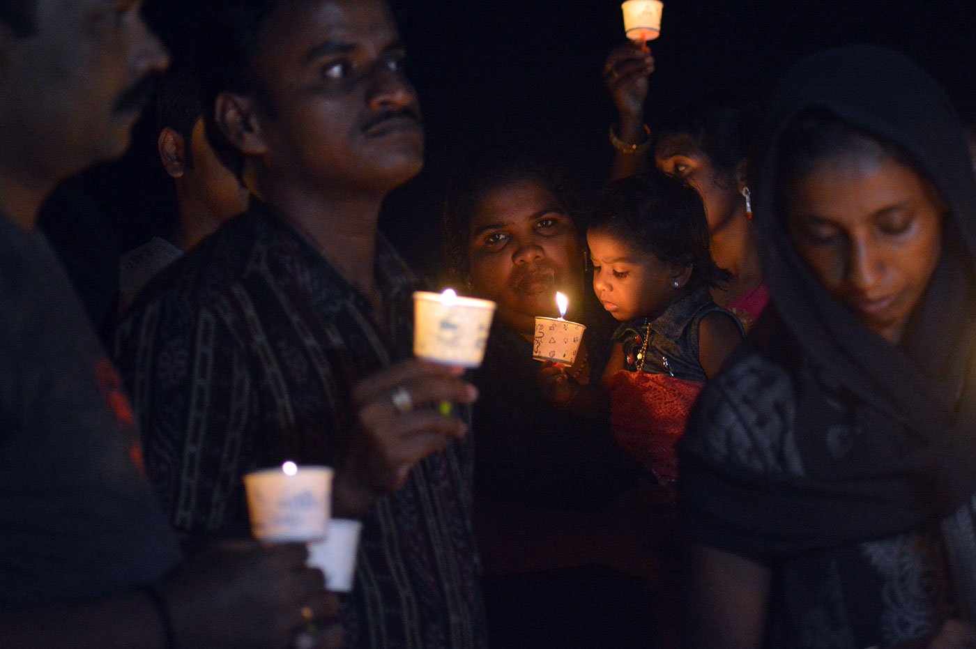 People holding candles at Christmas