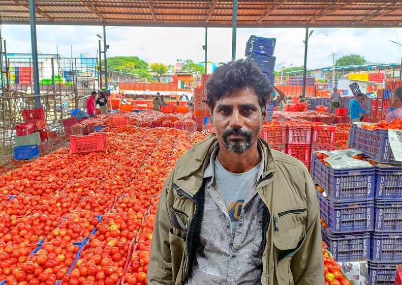 S. Sreenivasulu from Anantapur (left) sells his produce at Madanapalle market yard in Chittoor. The market yard is one of the largest trading hubs for tomatoes