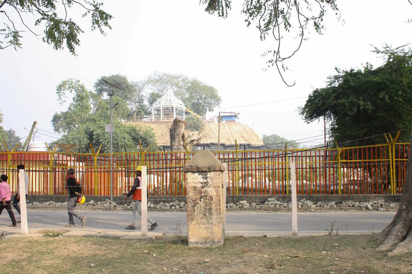 Left: Workmen for the temple passing through Durahi Kuan neighbourhood in front of the double-barricaded fence.