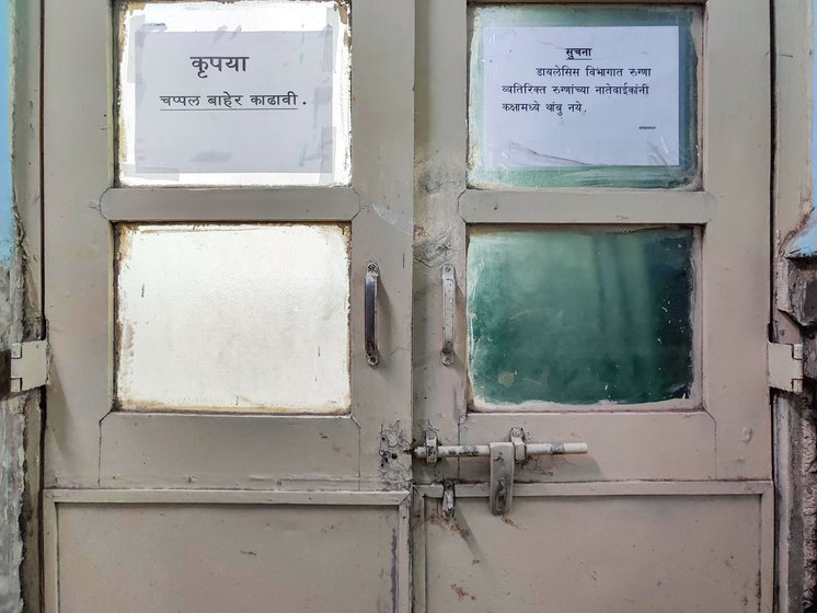 The door to the dialysis room prohibits anyone other than the patient inside so Dnyaneshwar (right) must wait  outside for Archana to finish her procedure
