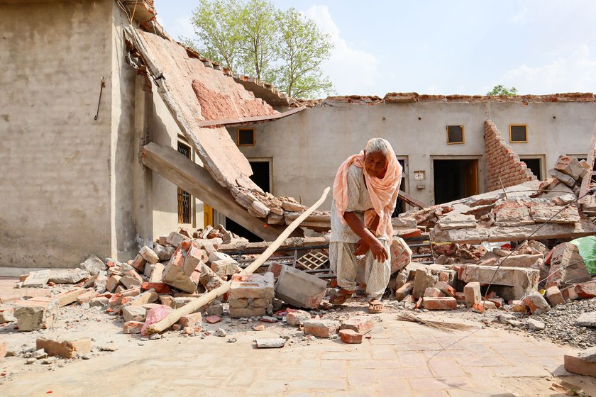 Left: Baldev Kaur picking her way through the rubble of her ancestral home.