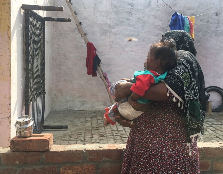 Manjit Kaur at home with her grandson (left); and the small container (right) in which she brings him milk. Manjit had borrowed Rs. 4,000 from an employer to buy clothes for her newborn grandson and for household expenses. She's been paying it back with the grain owed to her, and the interest in cash