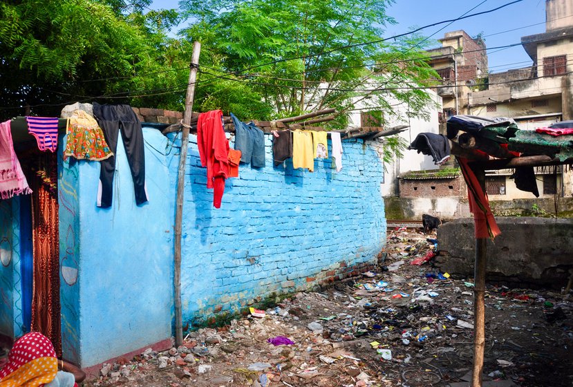 Left: Neetu's house is located alongside the railway track. Right: Women living in the colony have to wash and do other cleaning tasks on the unpaved street
