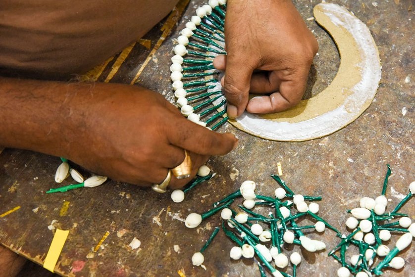 Upendra using sholapith flower buds to create the spokes for the crown worn by a Odissi dancer
