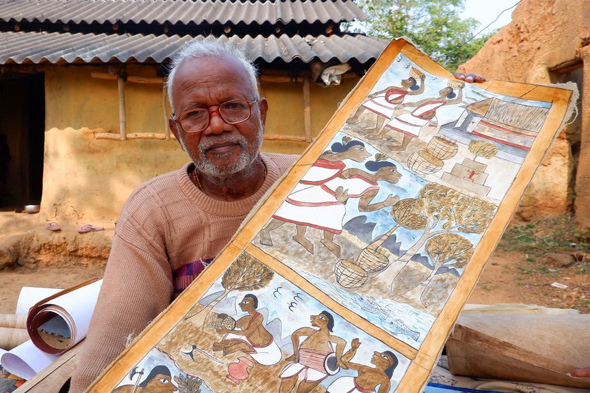 Anil Chitrakar, the oldest Paitkar artist in Amadobi village, with his paintings