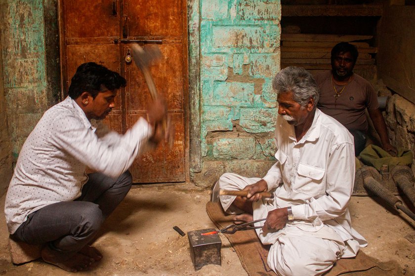 Heating the iron in a forge is challenging as it can cause severe burns, says Mohanlal. Kaluji (right), Mohanlal’s son-in-law, helping him hammer the red-hot iron