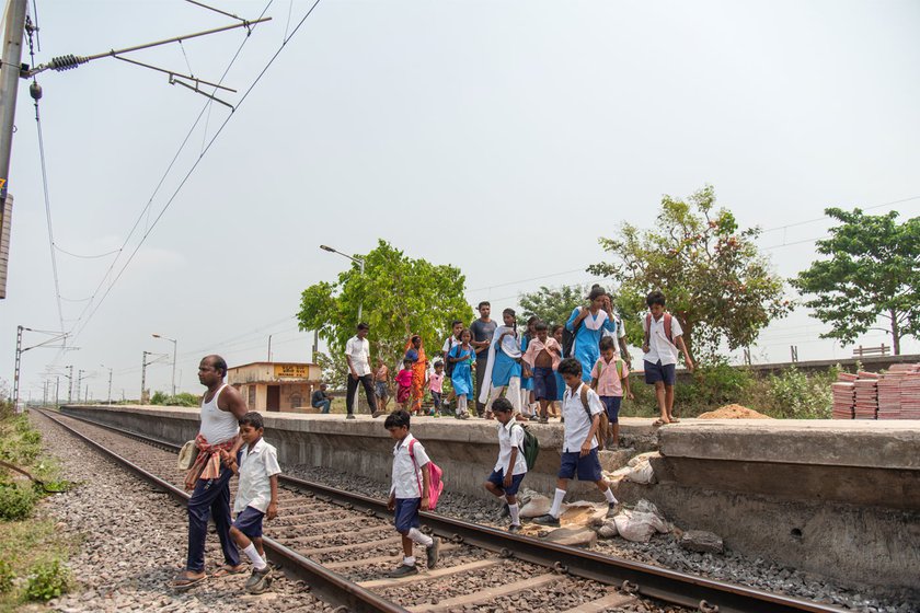 They cross a busy railway line while returning home with the children (right)