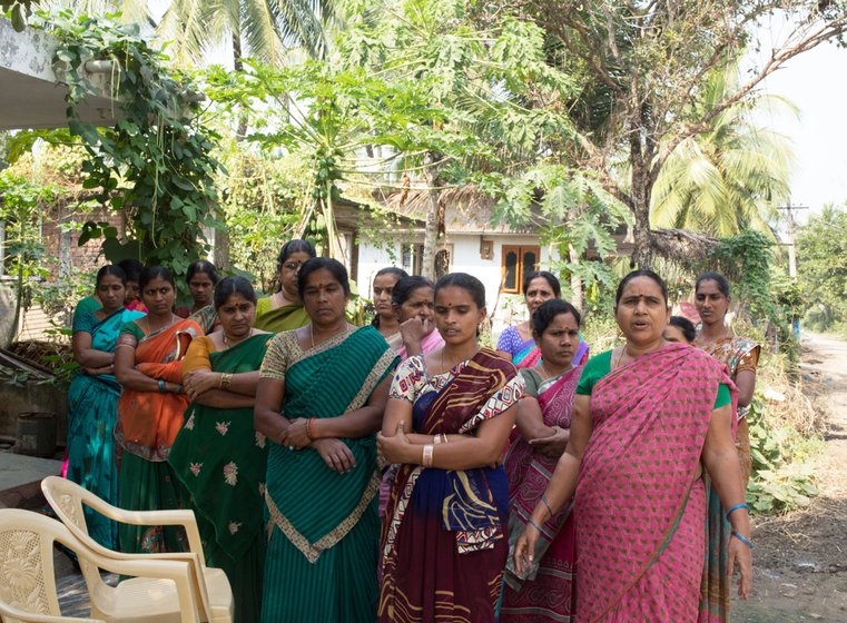A bunch of women standing outside a house