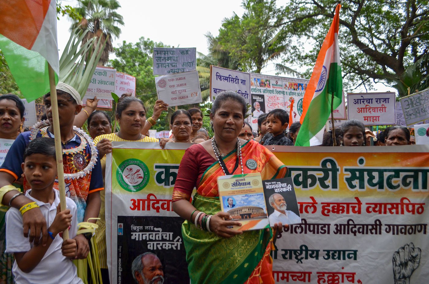 Shakuntala Dalvi, a KSS activist, holds up the Indian Constitution and a book written by Vitthal Lad
