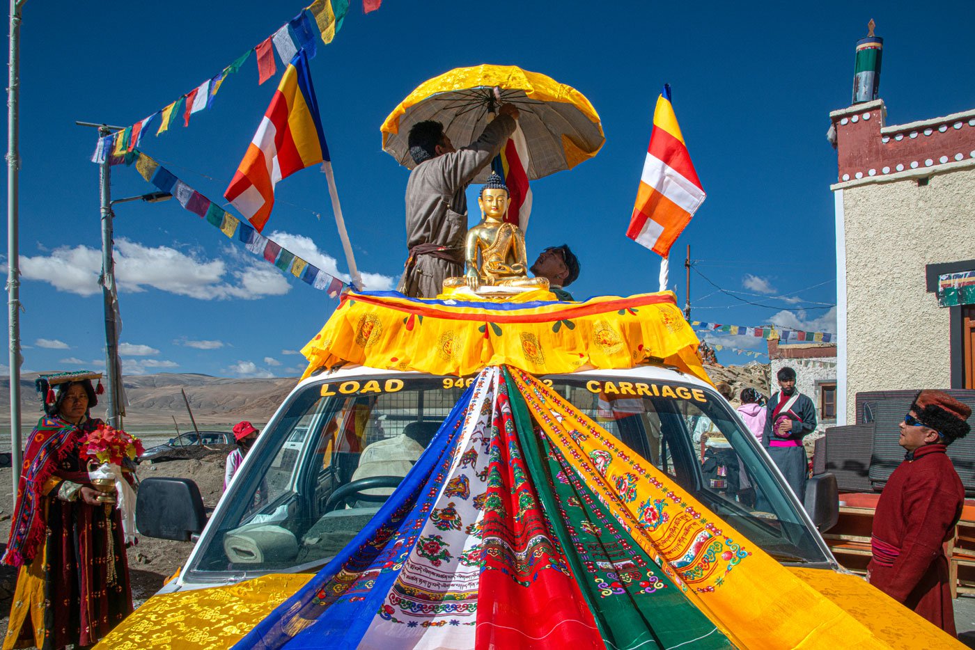 The idol is placed on a matador van covered with Tibetan prayer flags which are arranged in a specific order. Each colour in the flag represents an element and together they signify balance
