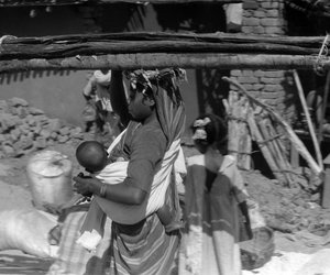 Woman carrying load and her baby going to the market