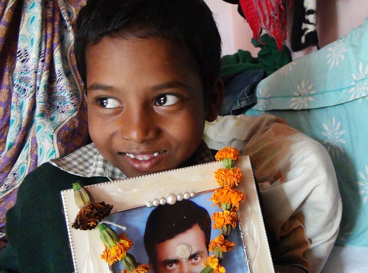 Left: Their son, Amit, 9, with his father's photograph: ' I will become an engineer and develop technology that will prevent humans cleaning gutters' Right: 'Caste matters', says Putul. 'I cannot get my husband back. I want only that no one else should have to face this ordeal '