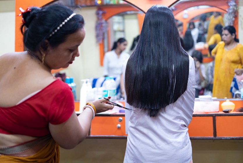 Pramila also trains young girls like Tuni Singh (yellow kurta) who is learning as she cuts 12-year-old Jasmine’s hair.