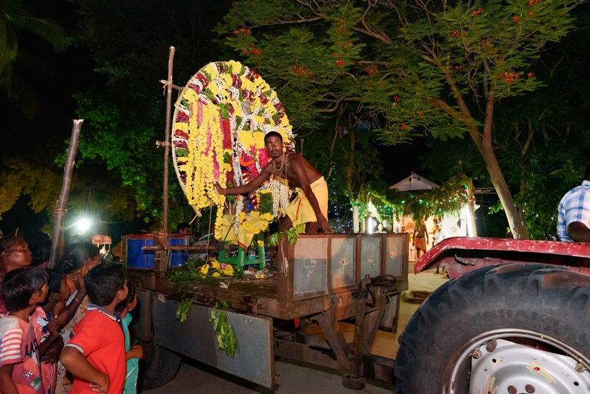 G. Subramani holds the thora on the tractor (left) carrying the amman deity.