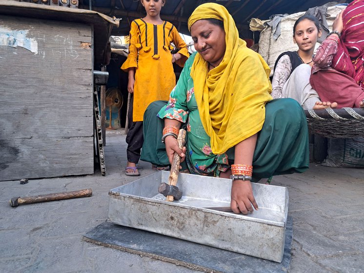 Salma uses a hammer and chisel to make a sieve which will be used by farmers to sort grain. With practiced ease, she changes the angle every two strikes