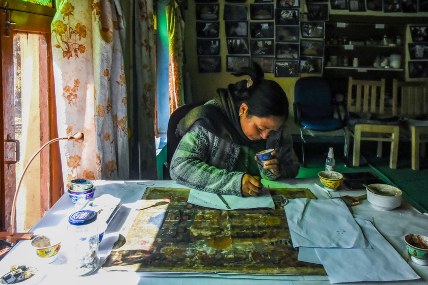 Left: One of the first members of Himalayan Art Preservers (HAP), Tsering Spaldon,  restoring a 17th century old Thangka painting.