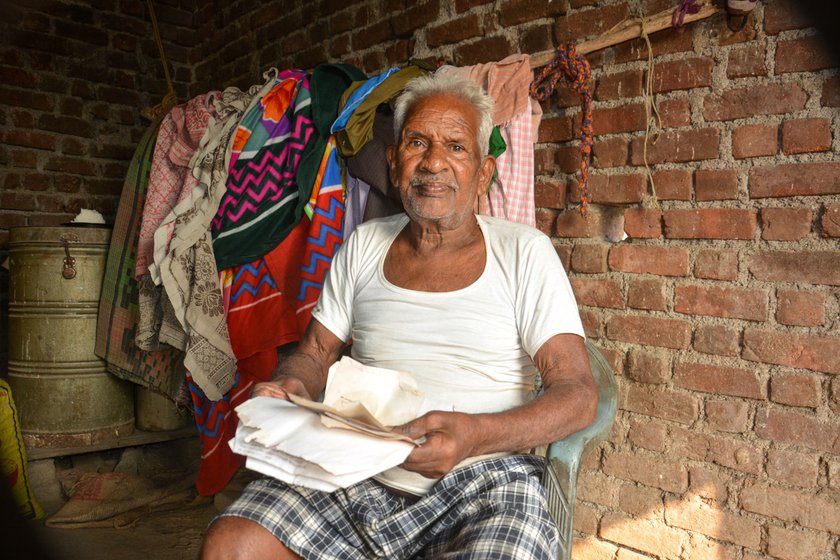 Damu Pared with old tax receipts of his home (right). He says, “I have lived here for many years, but now the government is saying that I have encroached on forest land"
