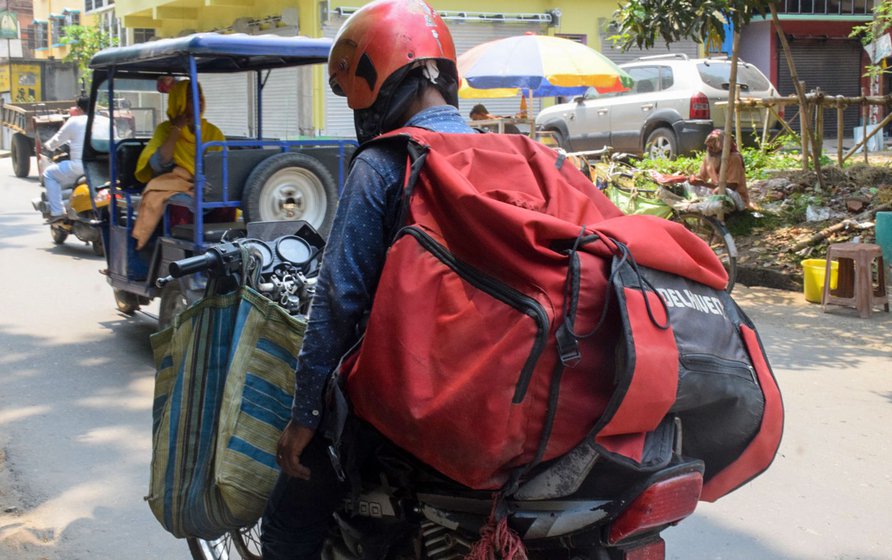 Some delivery agents like Sunder (right) have small parcels to carry, but some others like Ramesh (left) have large backpacks that cause their backs to ache