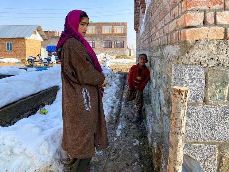 Left: Younger son Ali says, 'My father doesn’t have money, how can I go to school?' Right: The family's tin home behind Arshid's father’s house