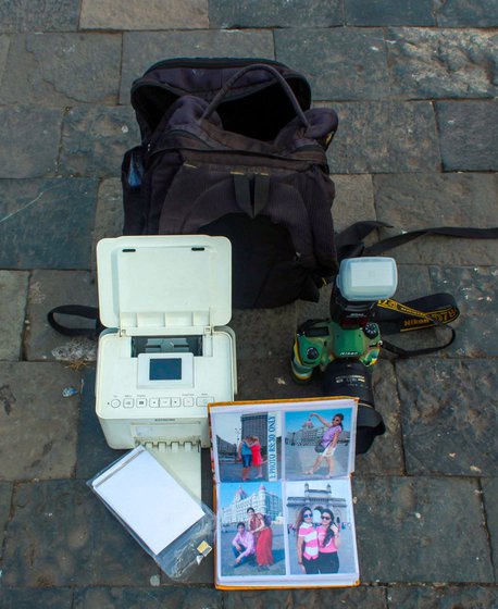 Tools of the trade: The photographers lug around 6-7 kilos – camera, printer, albums, packets of paper; some hang colourful sunglasses on their shirts to attract tourists who like to get their photos clicked wearing stylish shades