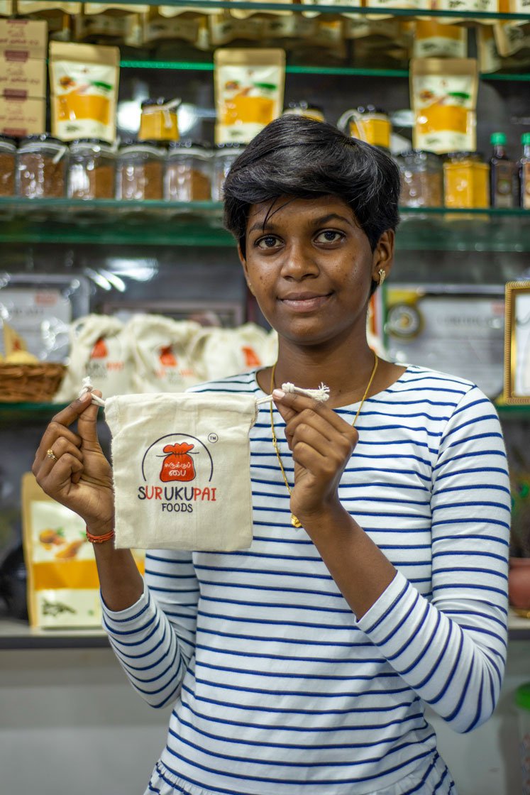 Left: Akshaya with a surukupai, or drawstring pouch, made of cotton cloth. Right: The Surukupai Foods product range