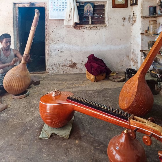 Right: Murugesan, a craftsman in Narayanan's workshop sanding down and finishing a veenai